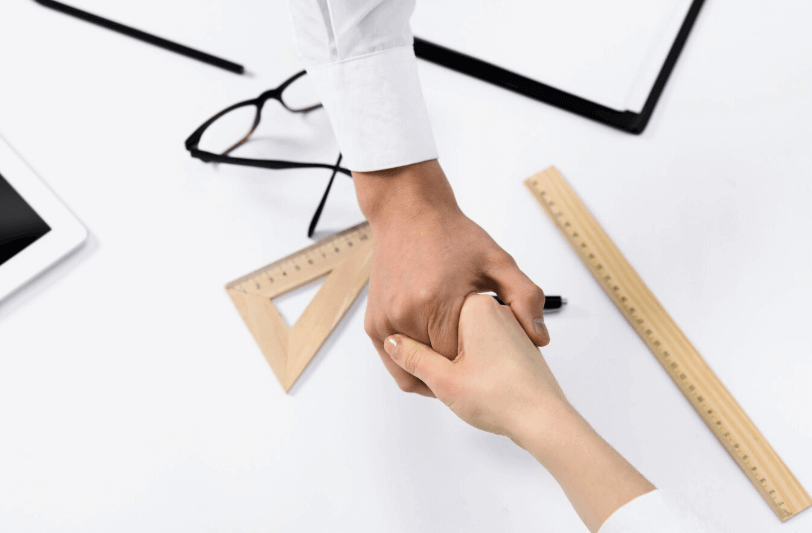 entrepreneur qui serre la main de son assistante commerciale